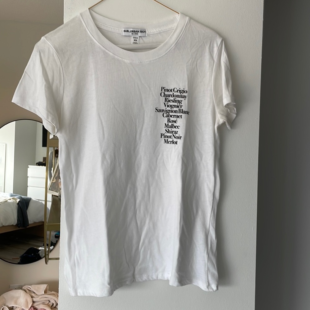 Sub_urban Riot xs tshirt. Corner of tshirt lists wine.